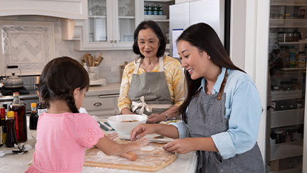 three generations of ladies cooking in the kitchen